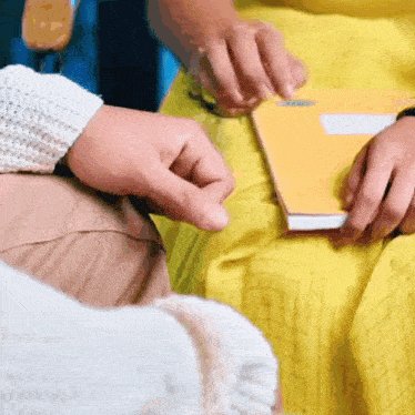 a person in a yellow dress is holding a book in their hands