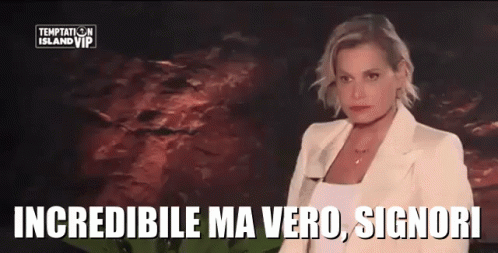 a woman in a white suit is standing in front of a sign that says " temptation island vip "