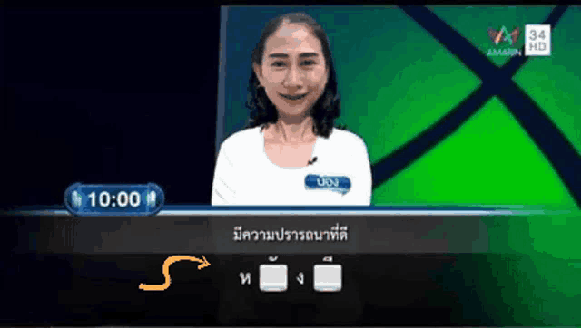 a woman stands in front of a green screen with a time of 10:00