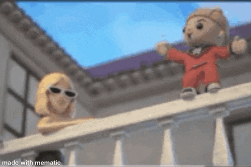 a teddy bear is standing on a balcony next to a woman .
