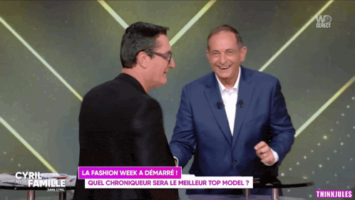 two men are laughing on a tv show called la fashion week