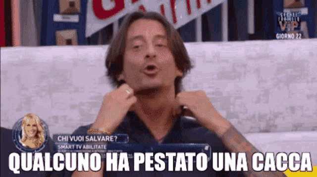 a man is sitting on a couch with the words qualcuno ha pestato una caccia written below him