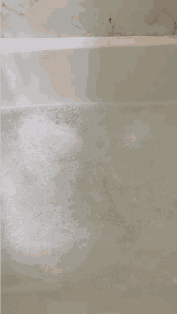 a stuffed polar bear is floating in a bathtub filled with bubbles