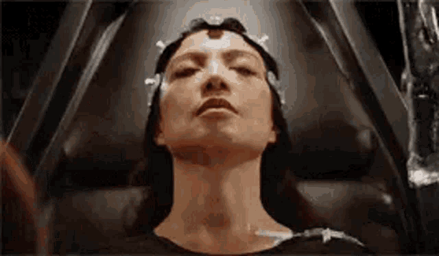 a woman is laying in a chair with her eyes closed and a syringe in her hand .