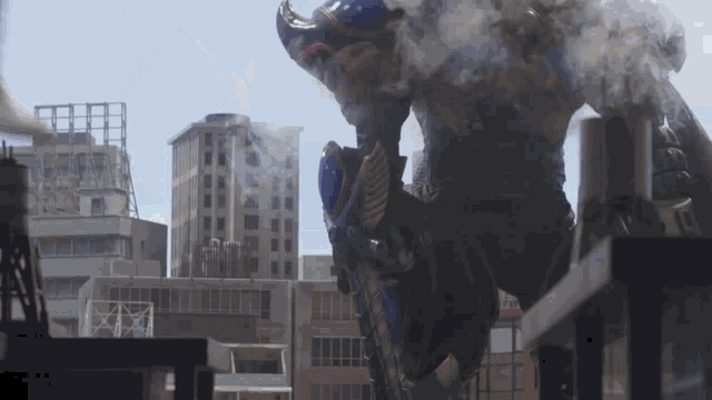 a monster is standing on top of a building in a city .