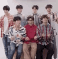 a group of young men are posing for a picture while standing next to each other .