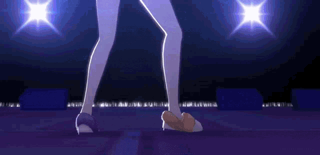 a woman 's legs are shown in front of a stage with purple lights and a few letters visible