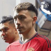 a man in a red shirt is standing next to another man in a black shirt .