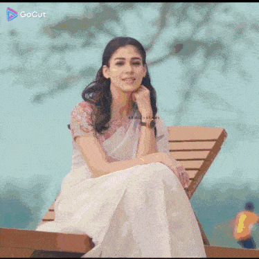 a woman in a purple dress is sitting in a chair with a gocut logo on the bottom
