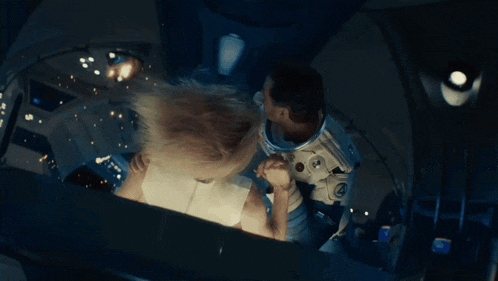 a man in a space suit with a nasa logo on his chest is standing next to another man
