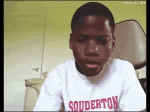 a young boy wearing a souderton t-shirt looks at the camera