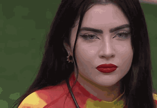 a close up of a woman 's face with red lips and earrings
