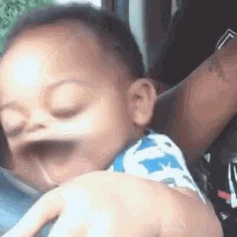 a baby is making a funny face while being held by a woman .