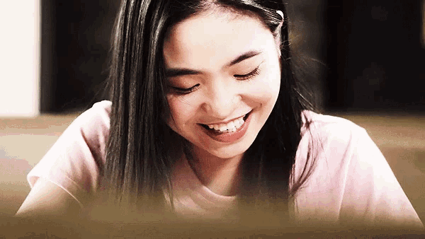 a woman is smiling with her eyes closed