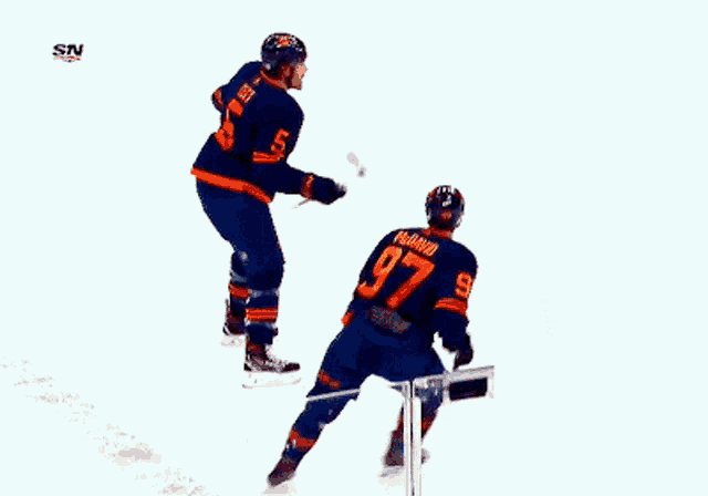 a hockey player with the number 5 on his jersey is hugging another player