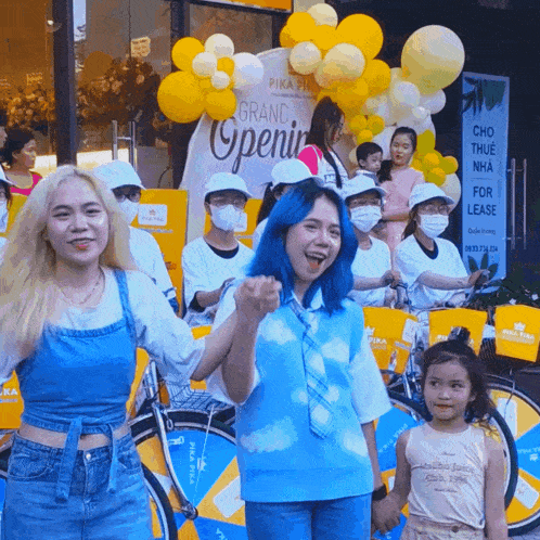 a group of people standing in front of a sign that says grand openin