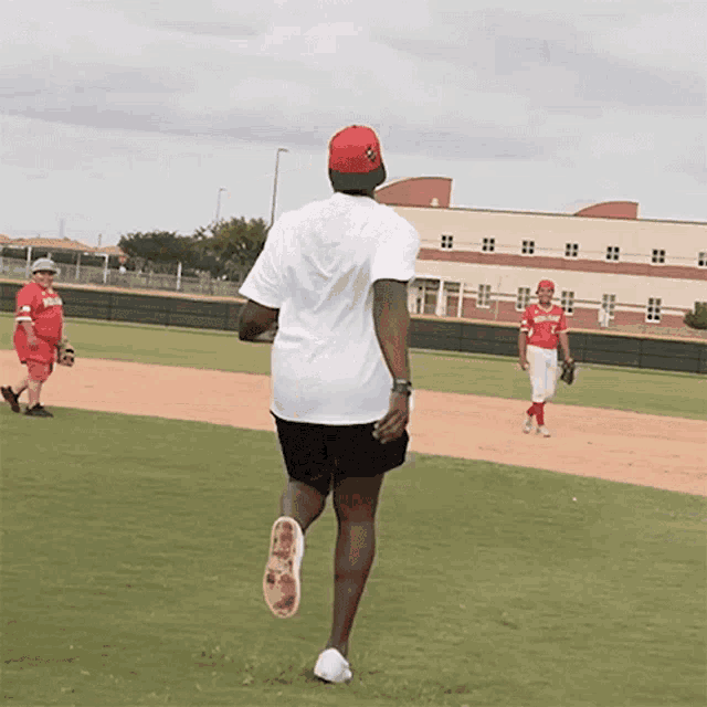 a man in a white shirt is running on a field