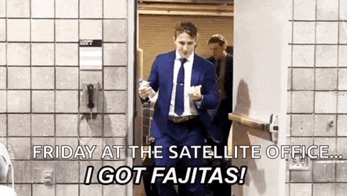 a man in a suit and tie is walking through a door holding a bottle of water .