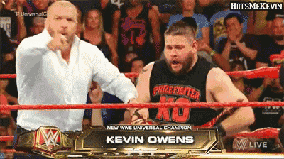 two men in a wrestling ring one of whom is kevin owens