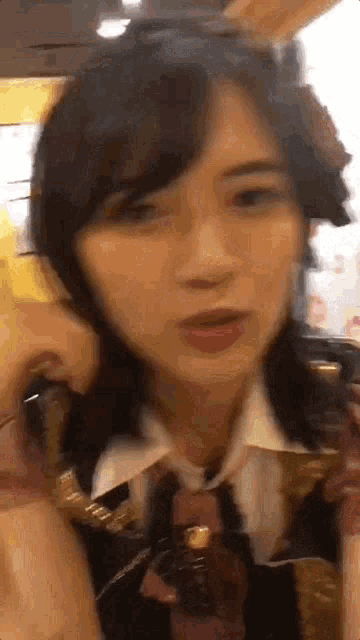 a close up of a woman talking on a cell phone while wearing a tie .