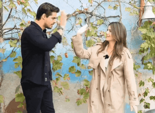 a man and a woman are giving each other high fives