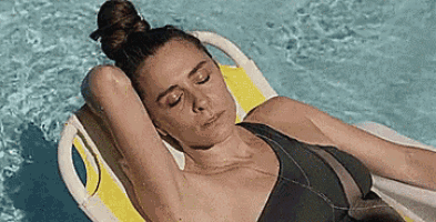 a woman in a bikini is laying on a raft in the water .