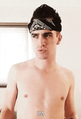 a shirtless man wearing a bandana on his head is making a funny face .