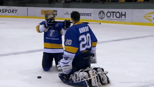 a hockey player with the number 20 on his back is kneeling on the ice