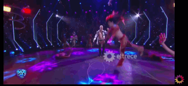 a group of people are dancing on a stage with eltrece written on the bottom