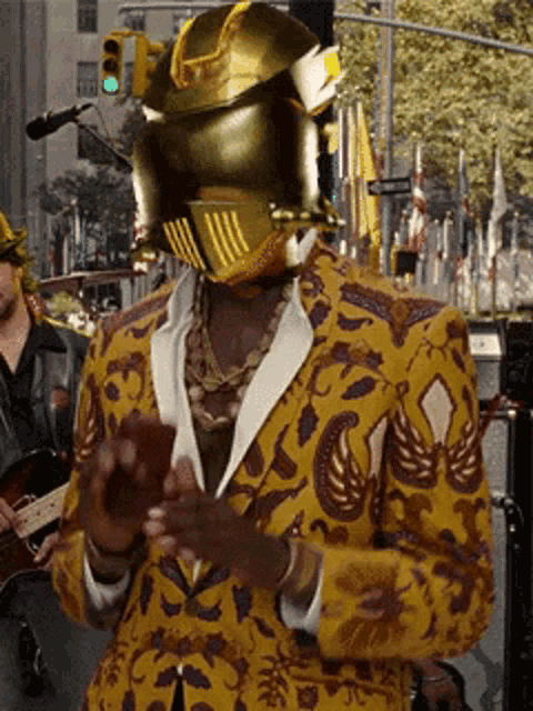 a man in a yellow suit has a helmet on his face