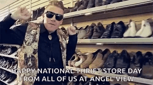 a man wearing sunglasses and a vest is standing in front of a shelf of shoes .