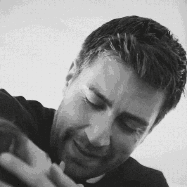 a black and white photo of a man 's face with his eyes closed