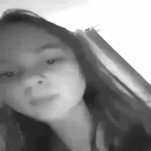a black and white photo of a woman 's face with a nose ring .