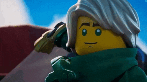 a close up of a lego figure with a green scarf around his neck and a sword in his hand .