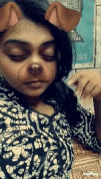 a woman wearing a snapchat filter with dog ears on her face .