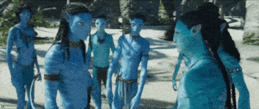a group of blue avatar characters are standing on a beach