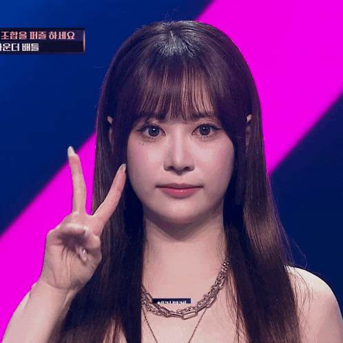 a woman giving a peace sign in front of a screen that says ' seoul '