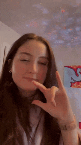 a girl with long hair is making a peace sign with her hand