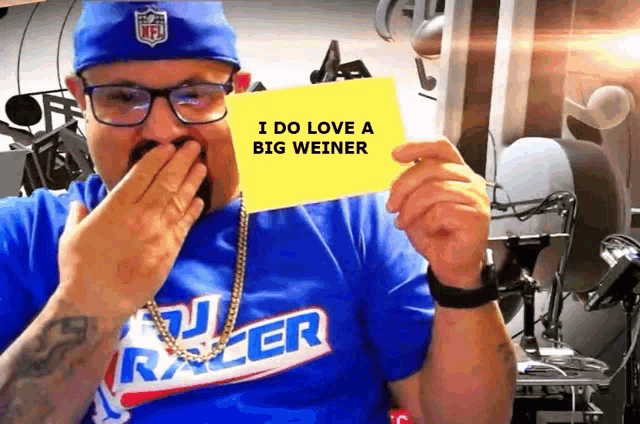 a man wearing a blue shirt that says i do love a big weiner holds up a yellow card