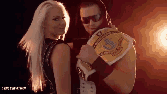 a man and a woman are posing for a picture and the man is wearing a world heavyweight wrestling belt