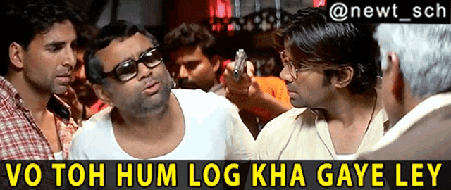 a group of men are having a conversation and one of them is holding a gun in his hand