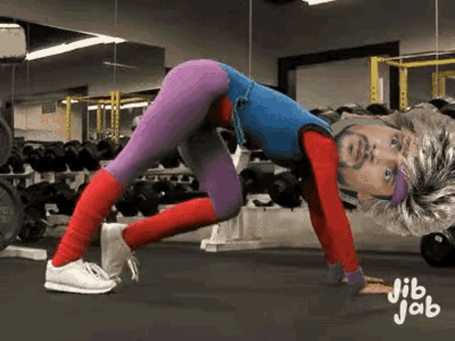 a person is doing push ups in a gym with a picture of a man on their back .