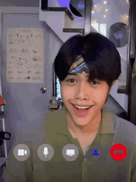 a young man wearing a headband is talking on a video call .