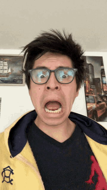 a man wearing glasses making a funny face with his mouth open