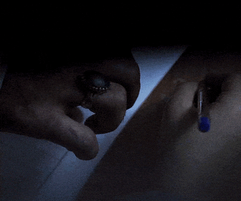 a person writing on a piece of paper with a pen