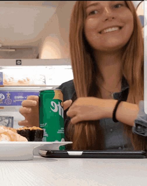 a woman holds a can of sprite in her hand