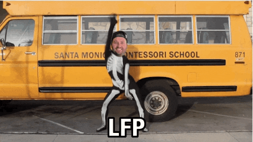 a man in a skeleton costume is standing in front of a school bus that says santa monica montessori school