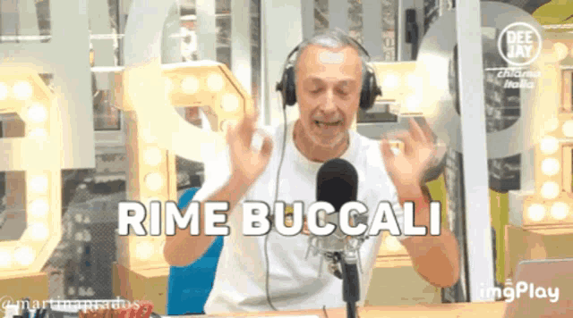 a man wearing headphones stands in front of a microphone and says rime bucali