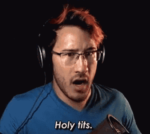 a man with red hair is wearing headphones and a blue shirt and says `` holy tits '' .