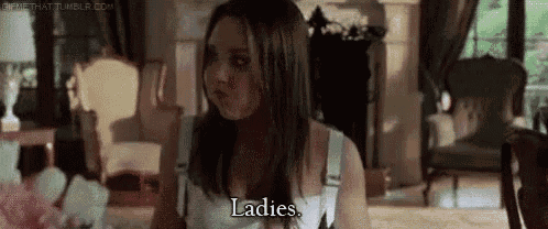 a woman is sitting in a living room talking to a man and says ladies .